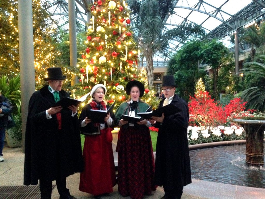 Doug Ballard, Jennifer Graf, Meghan Williams, and Ross Druker carol amidst the beautiful trees and fountains at Longwood in 2016.