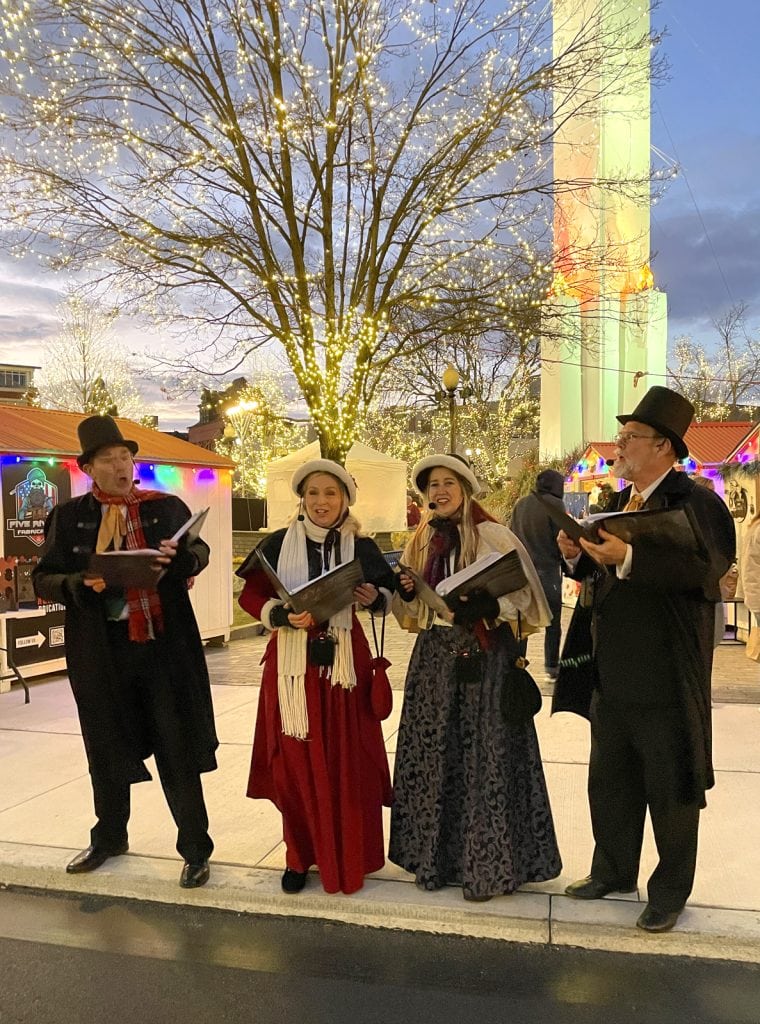 Caroling near the Peace Candle at the Easton Winter Market.